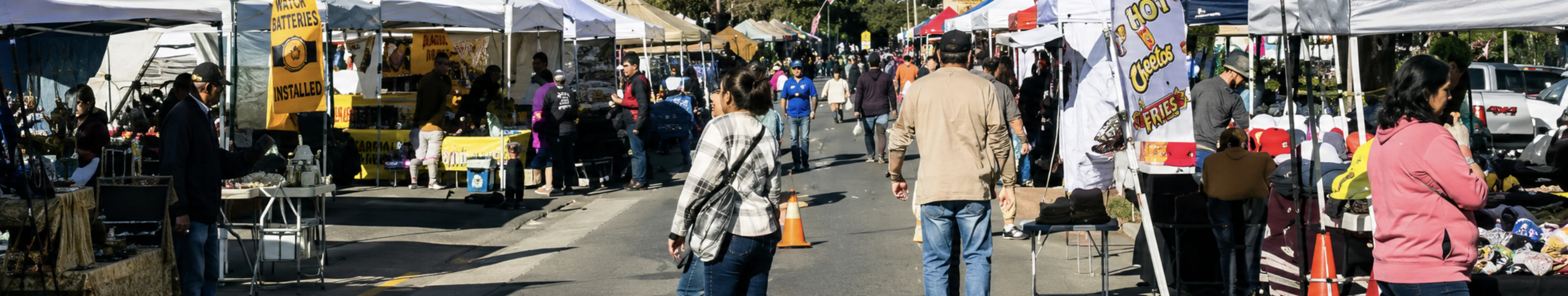 Visitors walking between vendor booths at the Morgan Hill Farmers Market